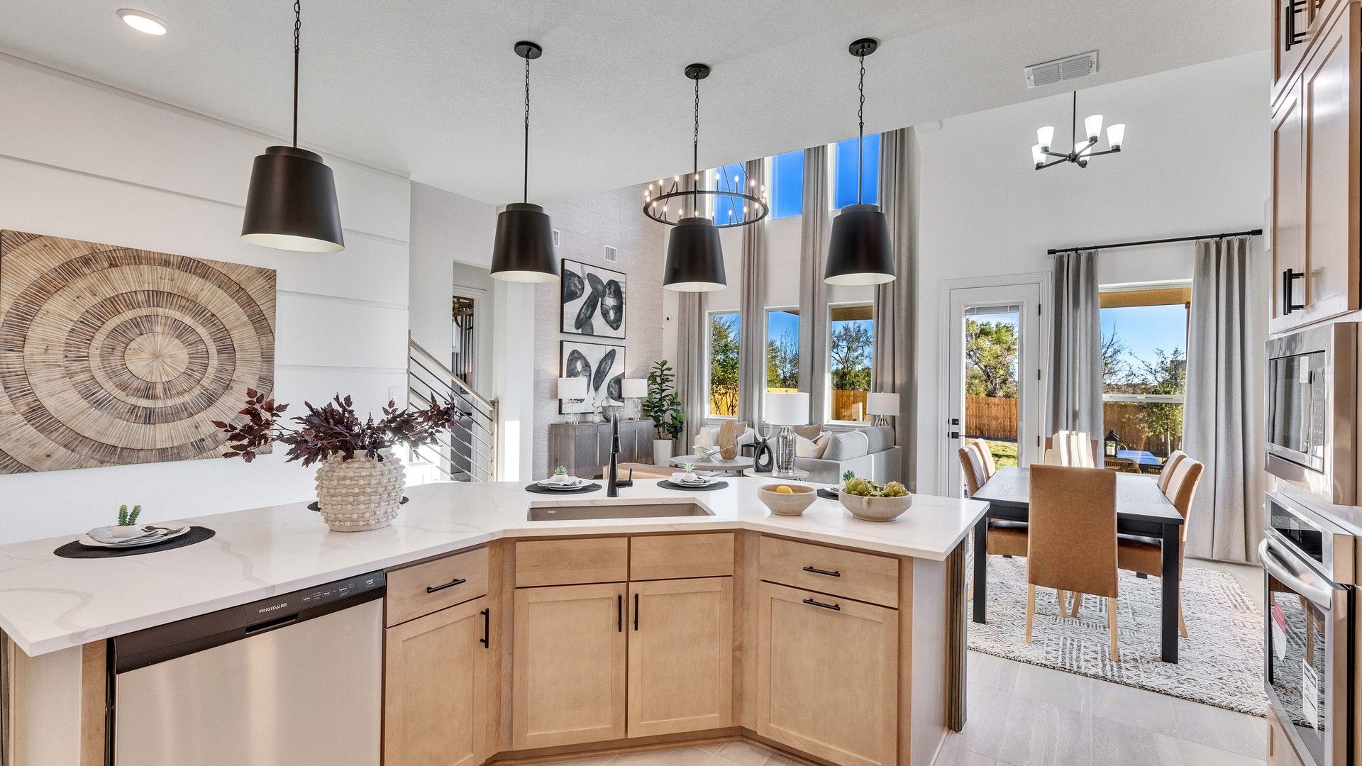 Step into luxury with this open kitchen and dining space, featuring chic pendant lighting and elegant wood finishes in Creeks Crossing.