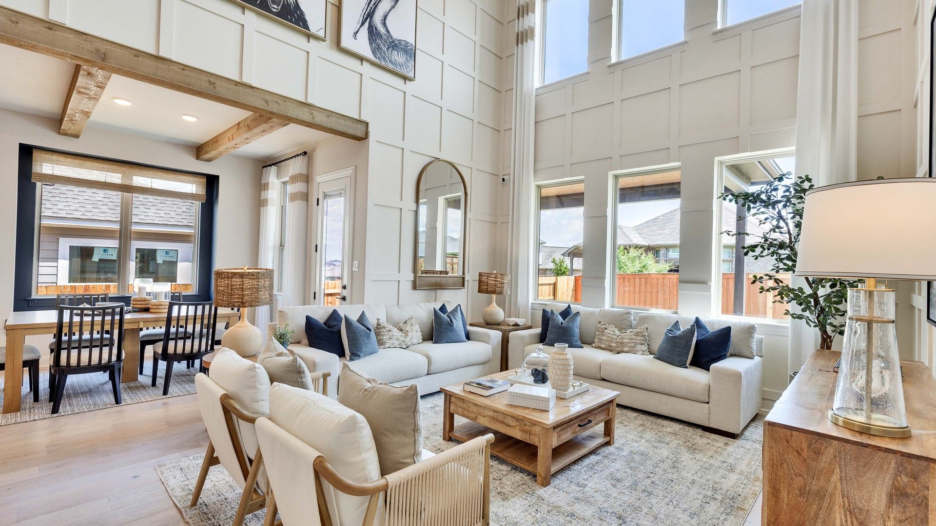 Sunfield's living room boasts soaring ceilings, elegant wood beams, and abundant natural light from grand windows.