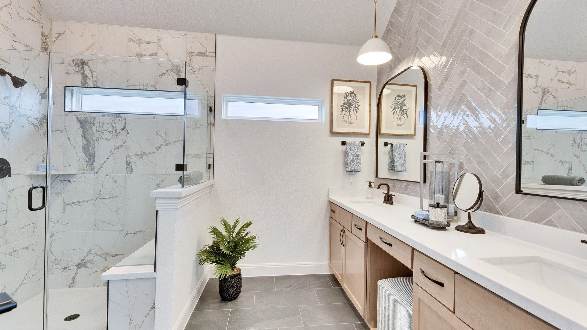 Elegant bathroom featuring marble, herringbone tiles, and dual sinks. Spring Creek community sophistication.