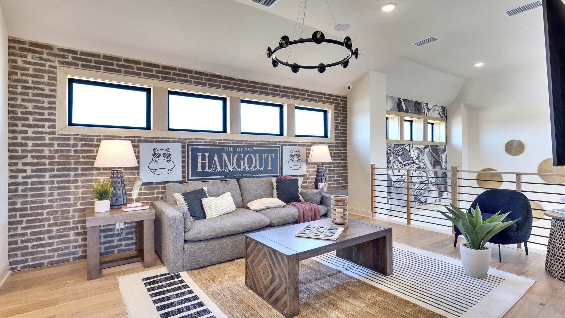 Elegant brick accent wall and chic decor in Flora community create a luxurious ambiance.