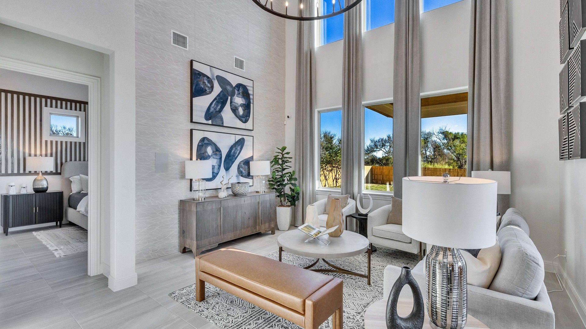 Expansive windows and soaring ceilings define this luxurious Creeks Crossing living space, emphasizing elegance.