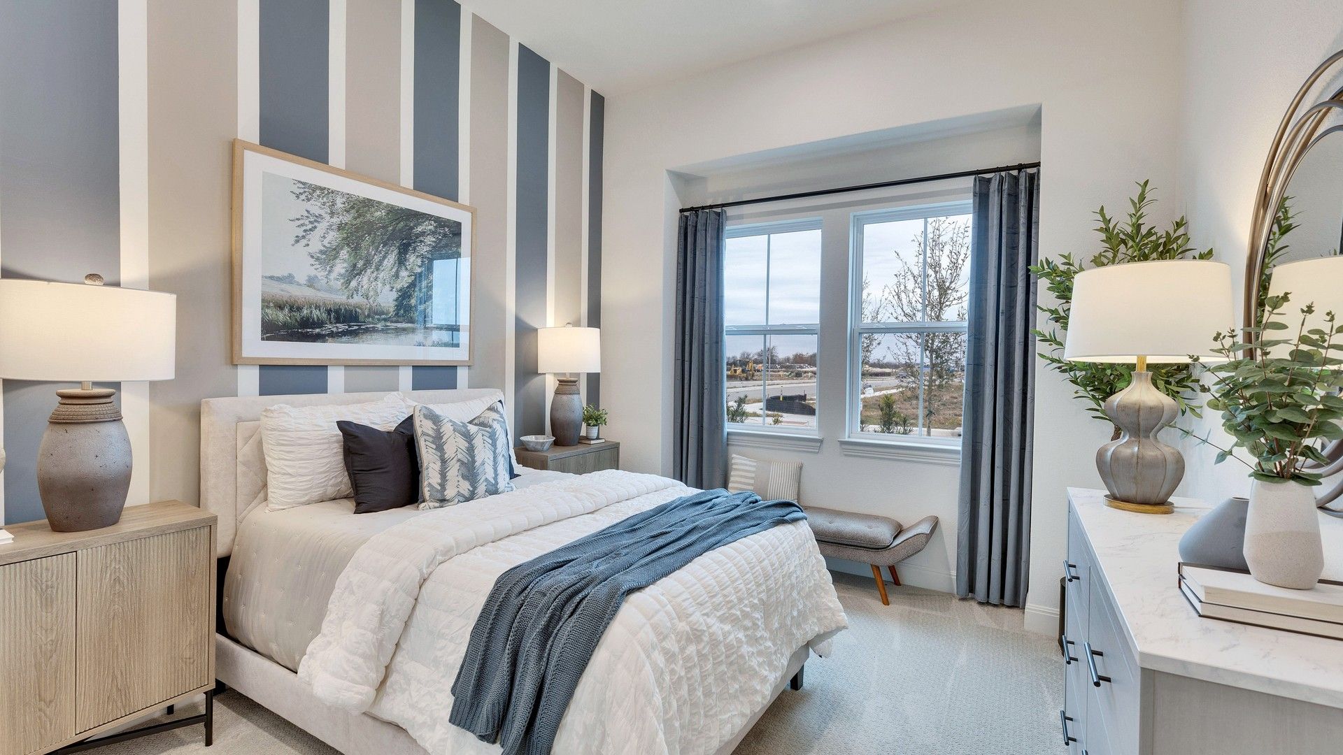 Spring Creek bedroom boasts a sophisticated striped accent wall, expansive window views, and high-end finishes.