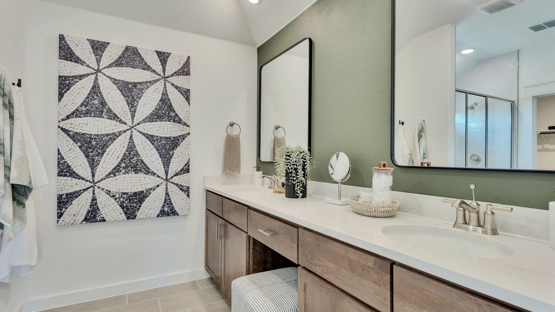 Dual sinks with marble counters and chic tile art elevate luxury in Hunters Glen.