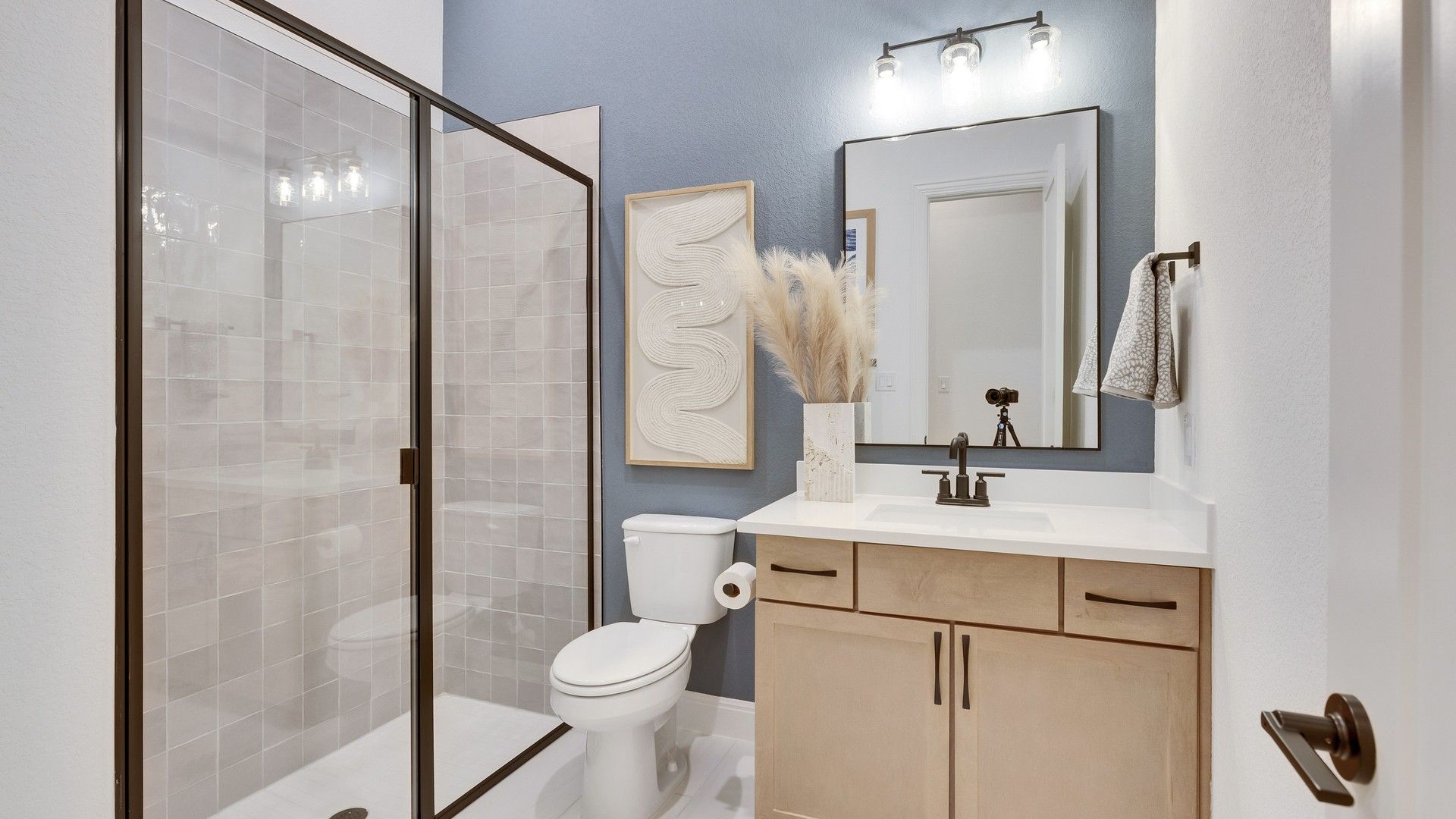 Elegant glass shower, stylish vanity with sleek fixtures in Spring Creek's refined atmosphere.