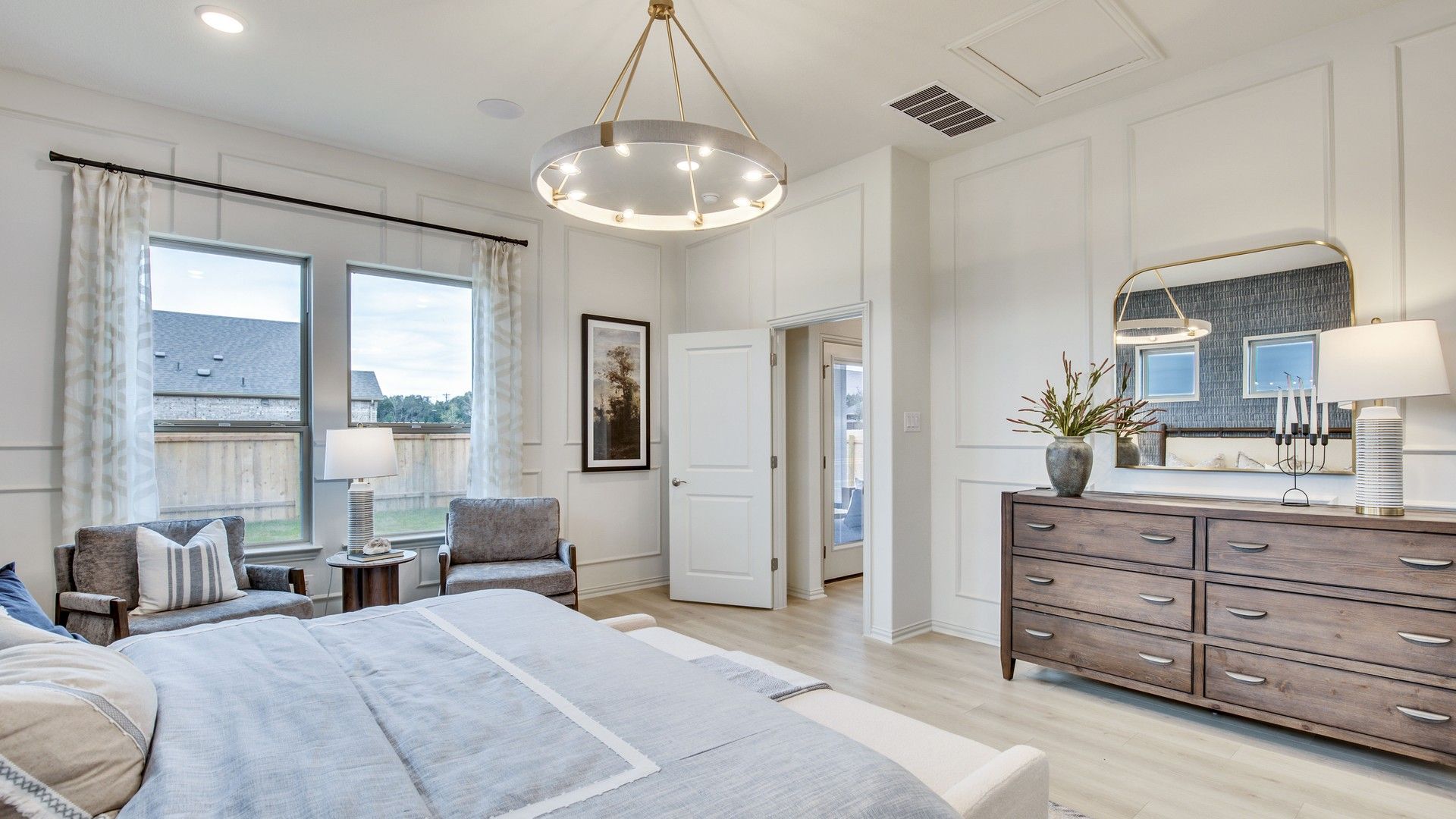 Elegant Opal Ranch bedroom features refined wall molding and luxurious wooden dresser design.