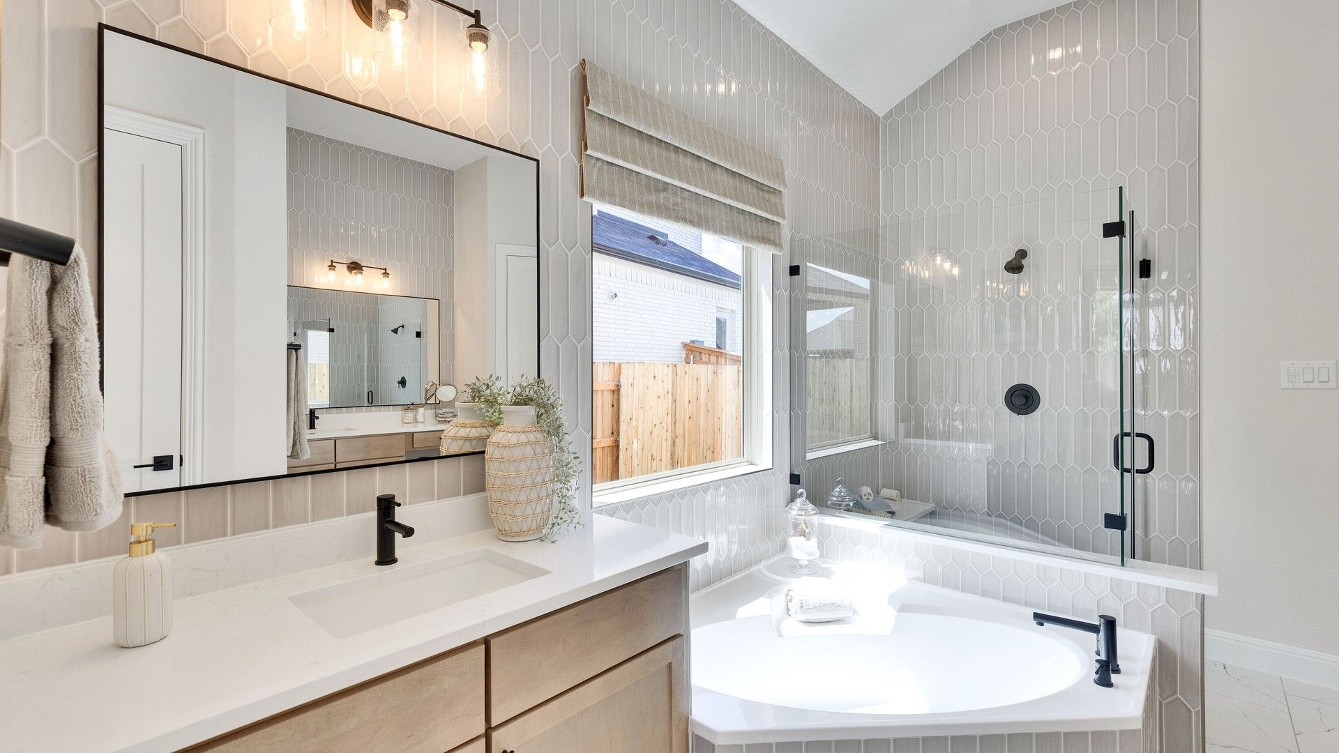 Experience refined luxury with hexagonal tiled walls and elegant fixtures in Sunfield's exquisite bathroom design.
