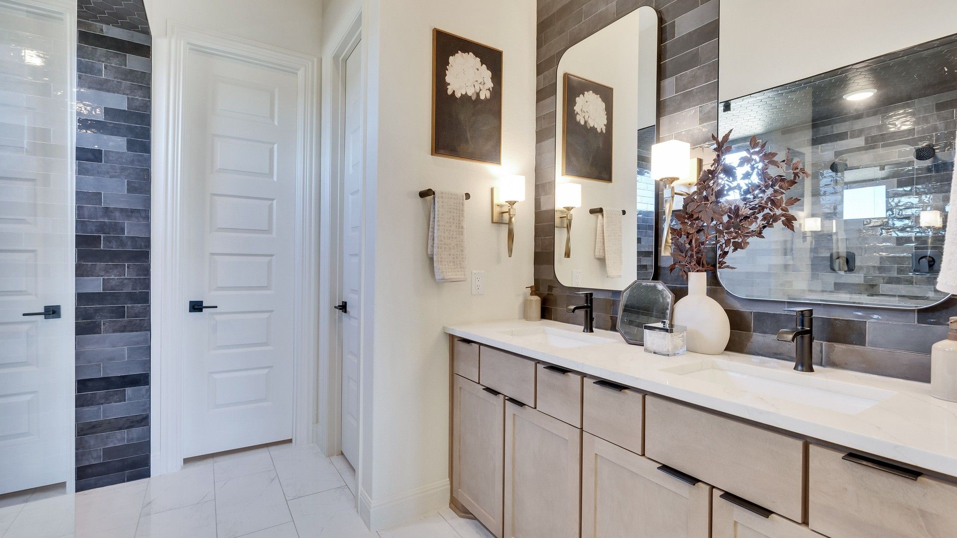 Experience refined luxury with a dual vanity and sleek tile work in Flora’s elegant bathroom spaces.