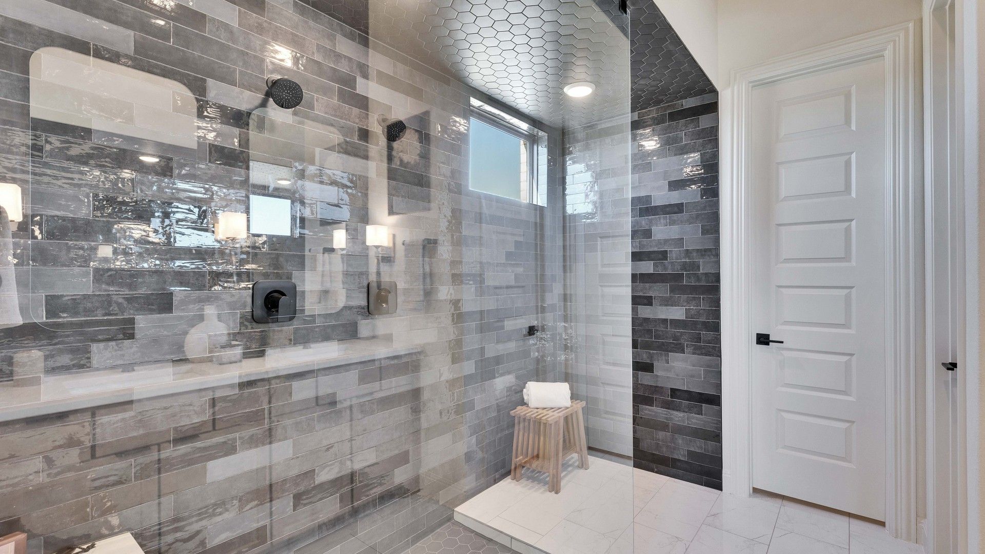 Experience opulence in a shower featuring hexagonal tiles and high-end fixtures in Flora community's modern design.