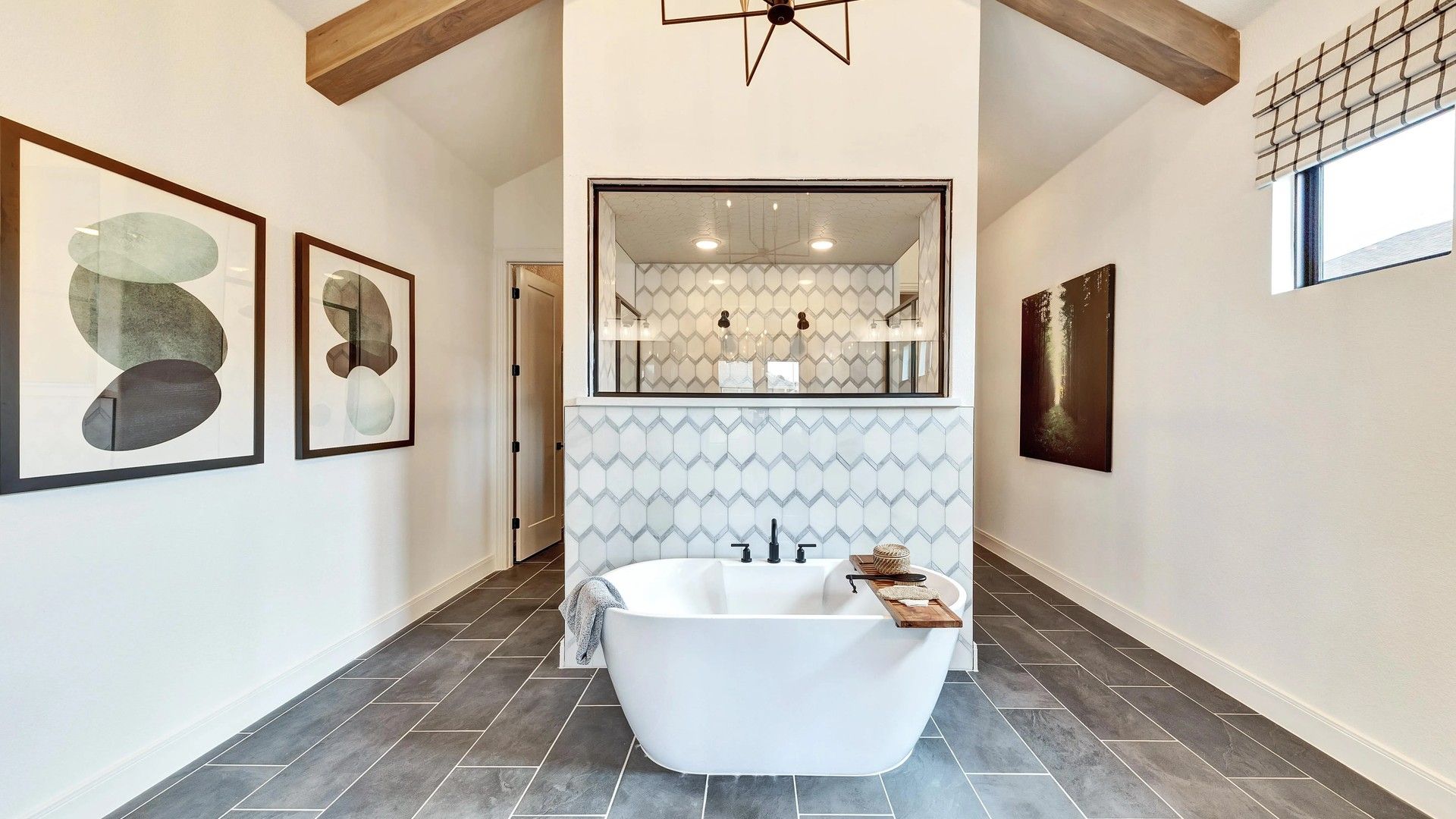 Indulge in Hawkes Landing's elegant bath with freestanding tub, geometric tile, and a chic exposed beam ceiling.