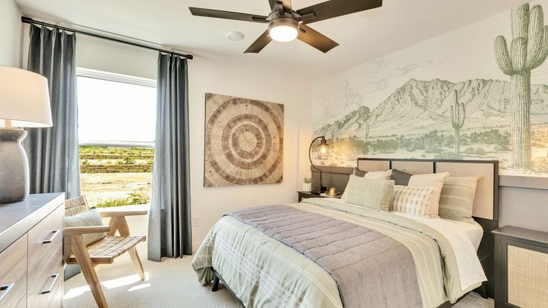 Discover elegance in this Hunters Glen bedroom, featuring a stunning mountain mural and sleek fan.