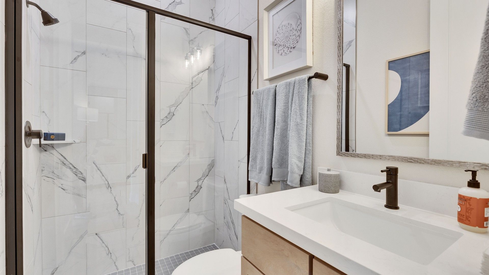 Discover refined elegance with marble tile shower and modern fixtures in Sunfield's luxurious bathroom.