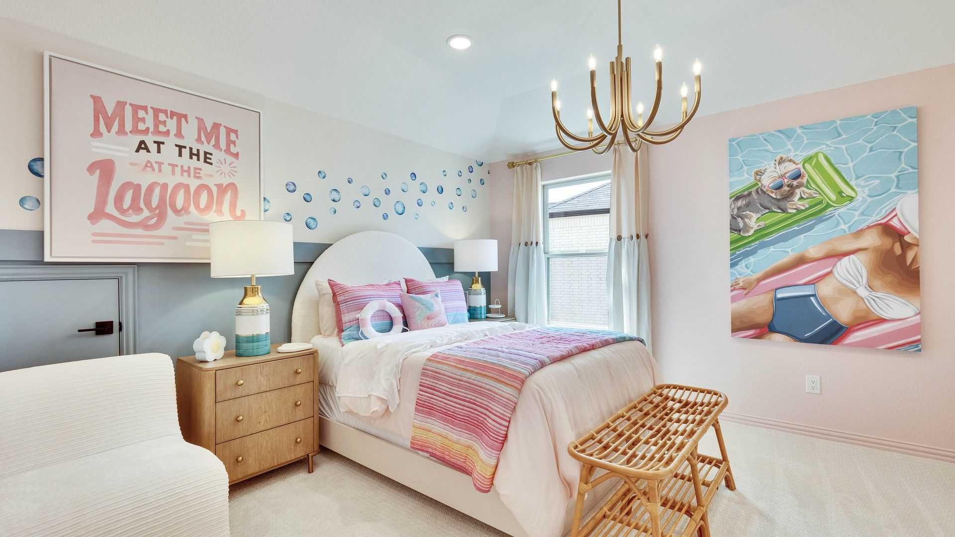 Luxurious bedroom featuring pastel hues, elegant chandelier, custom art in Sunfield community.