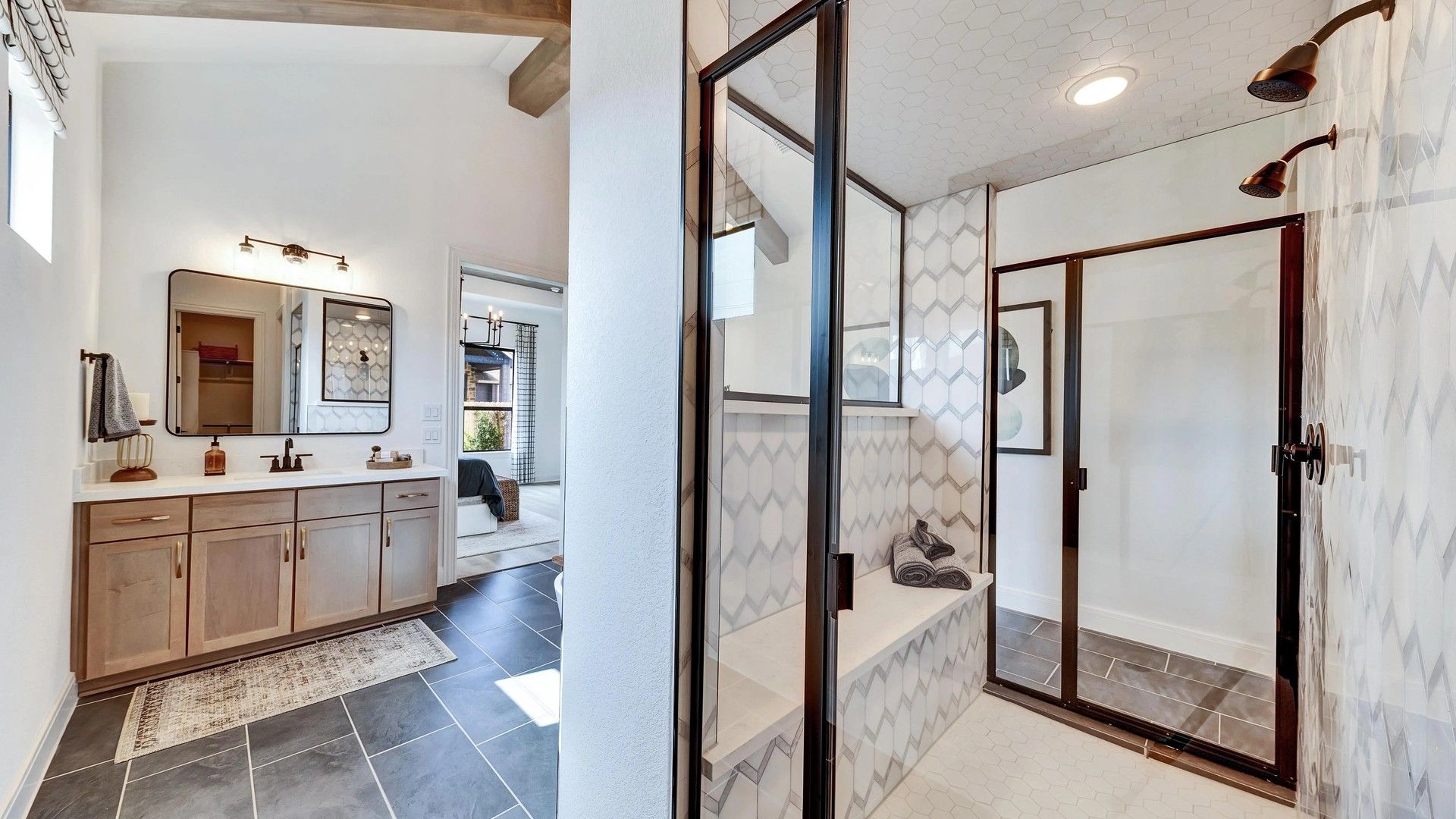 Expansive glass shower and hexagonal tiles accentuate this Hawkes Landing bathroom masterpiece.
