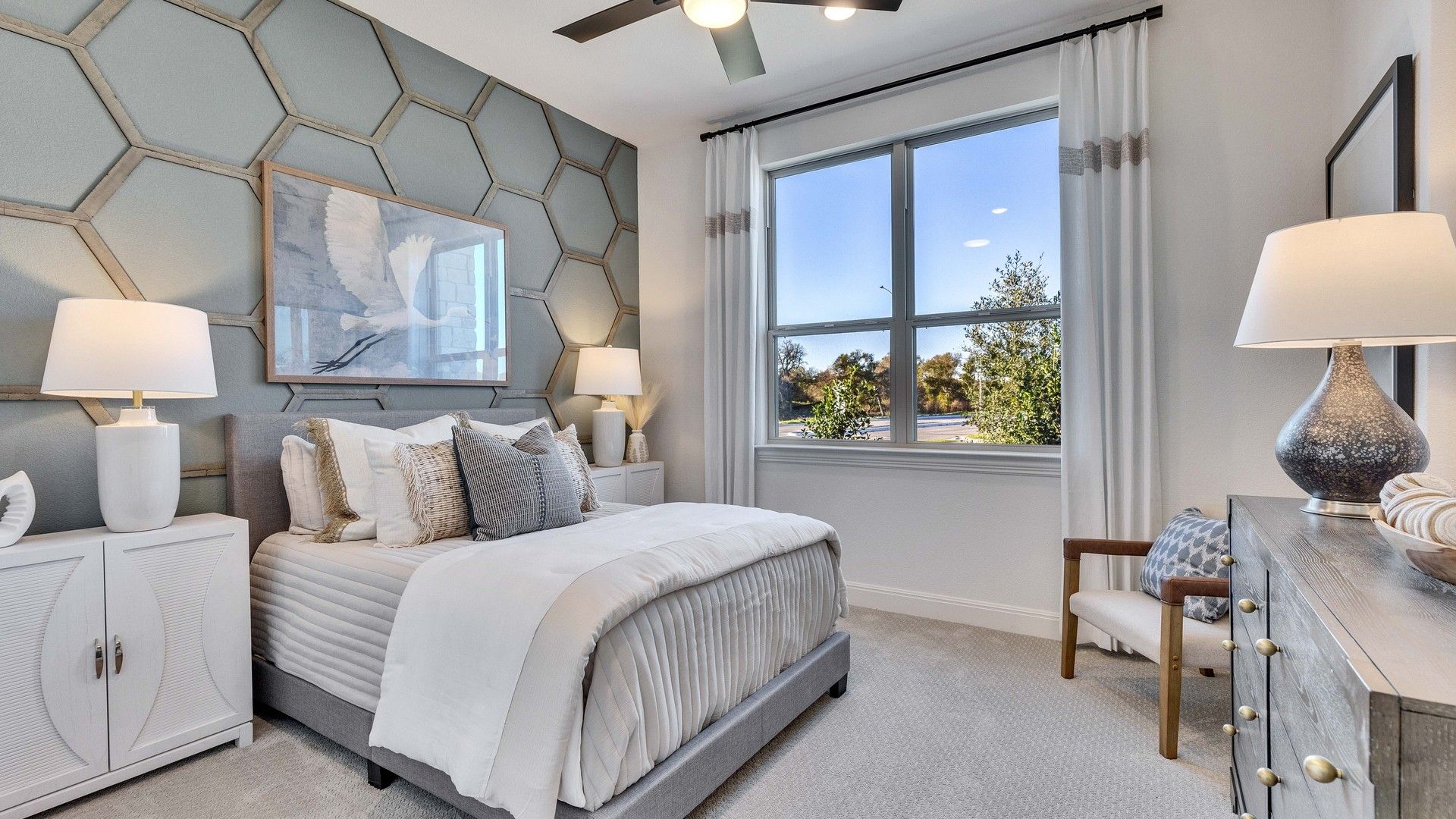 Hexagonal wall and modern décor highlight this Creeks Crossing bedroom. Luxurious window views accentuate space.