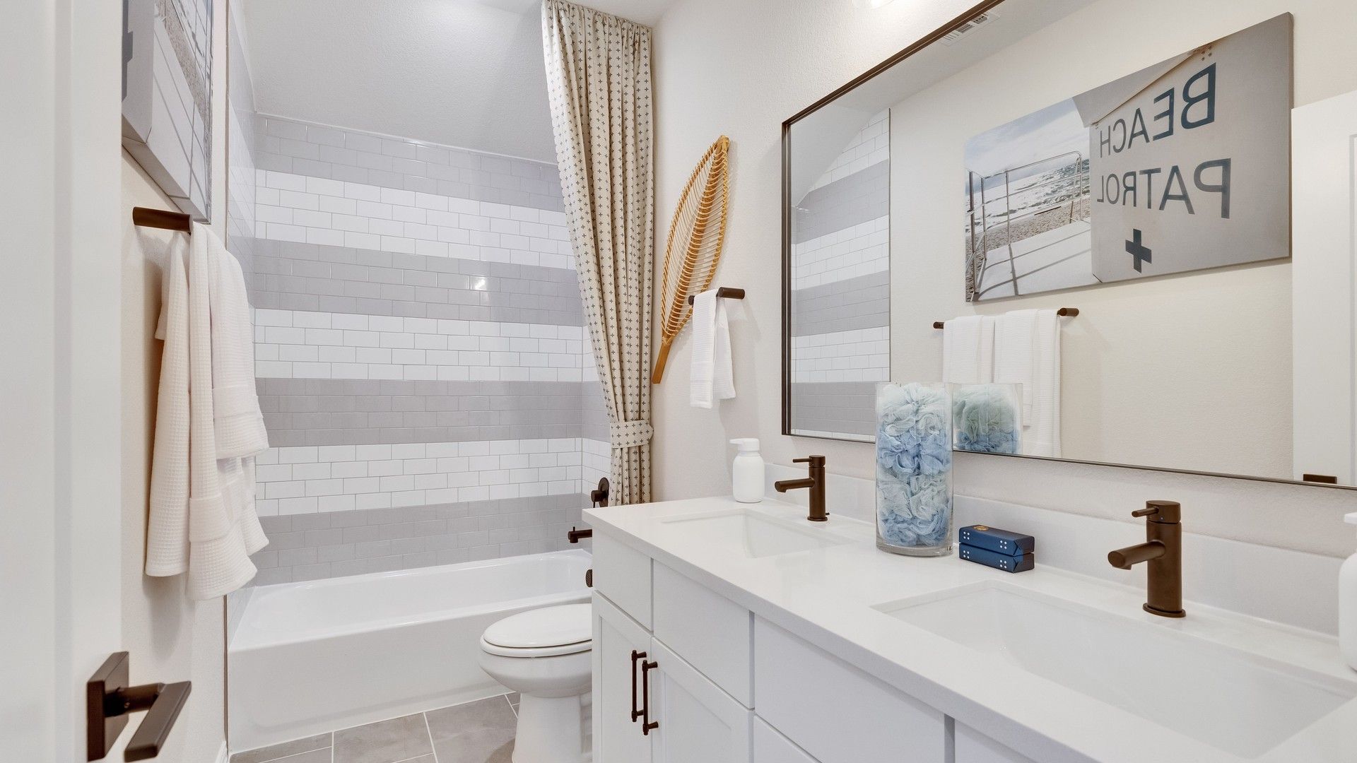 Luxurious double vanity with sleek bronze fixtures and designer subway tiles in Sunfield's upscale bathroom.