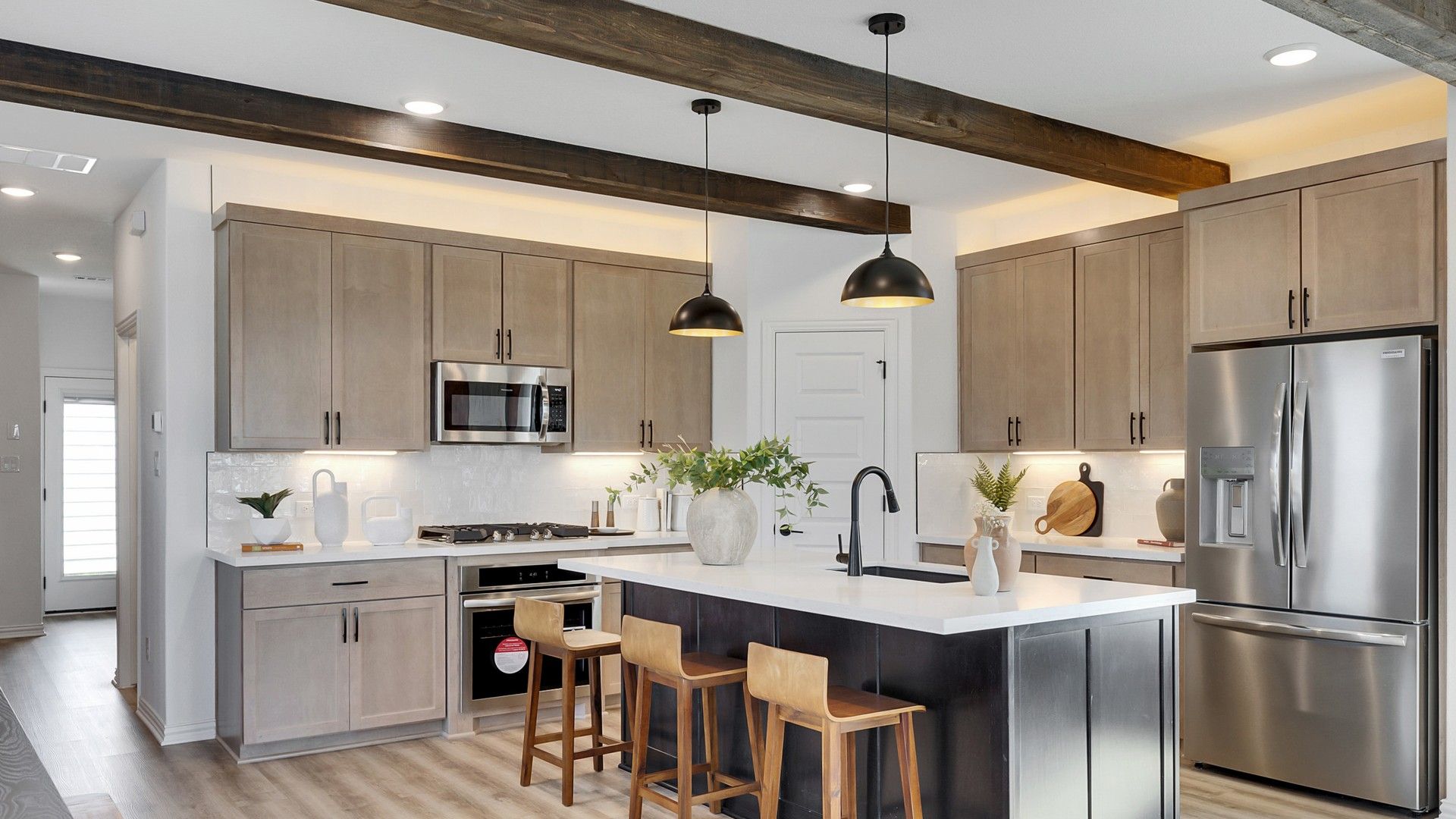 Luxurious kitchen features sleek wood cabinetry, premium appliances, and a spacious island in Spring Creek.