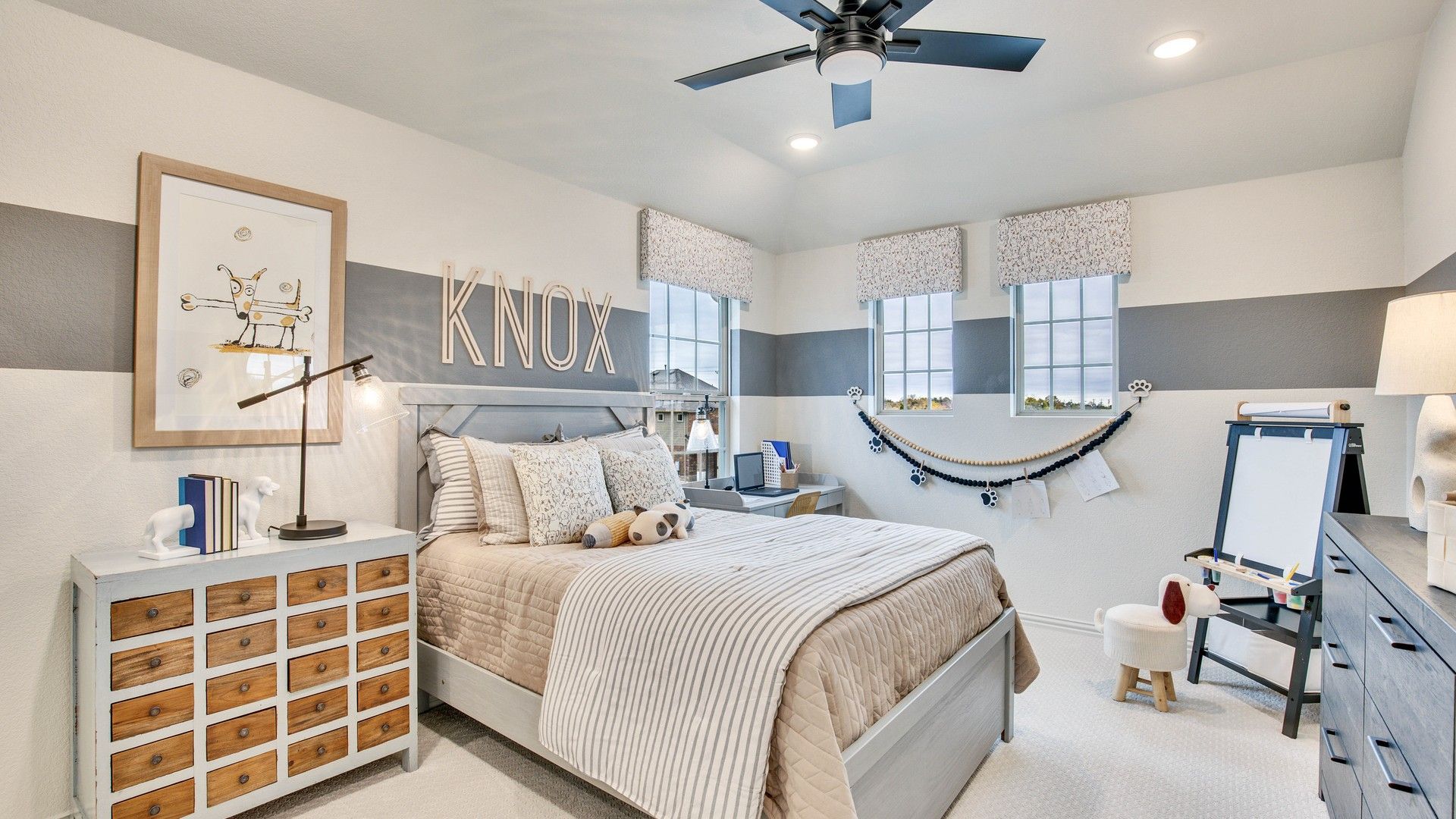 Elegant custom wall art and chic wooden furniture create a stylish child’s bedroom in Opal Ranch.
