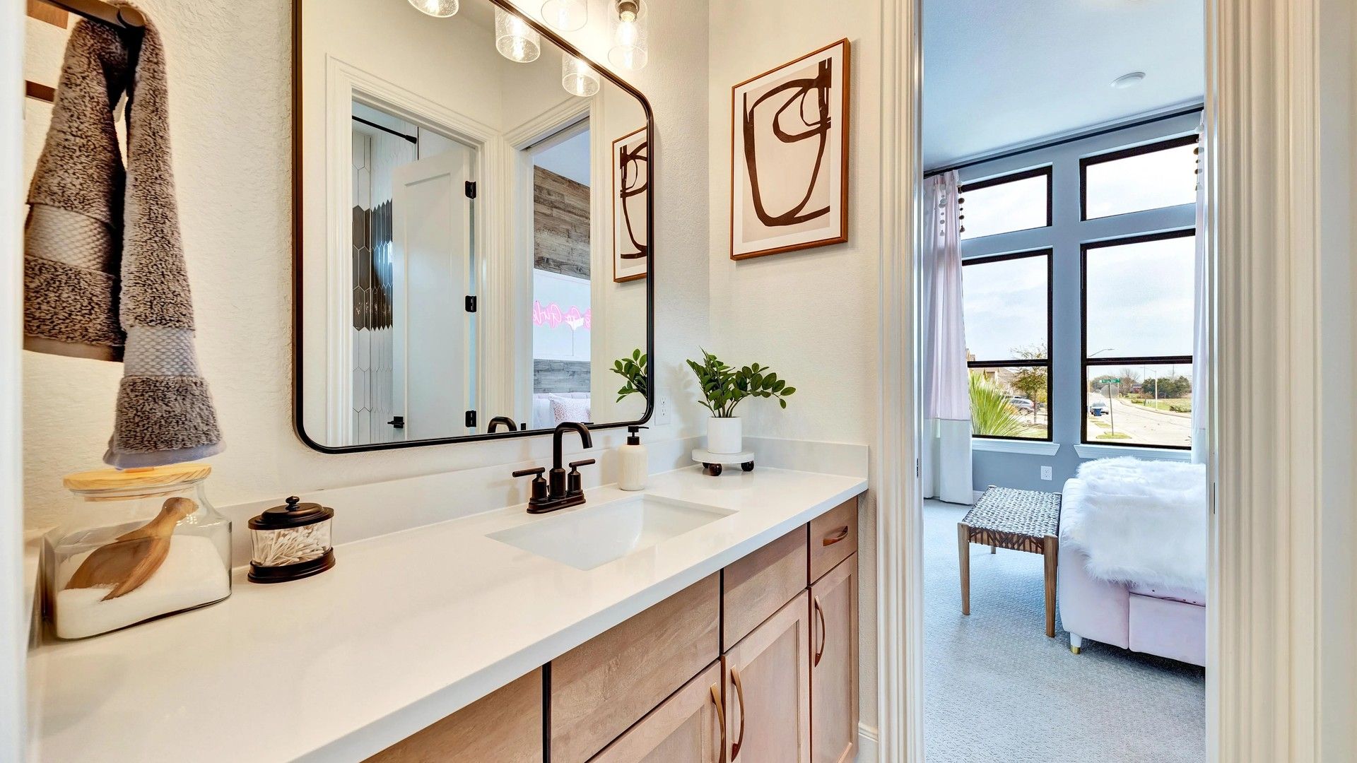 Luxurious wood cabinetry and sleek black fixtures enhance this Hawkes Landing bathroom's modern elegance.