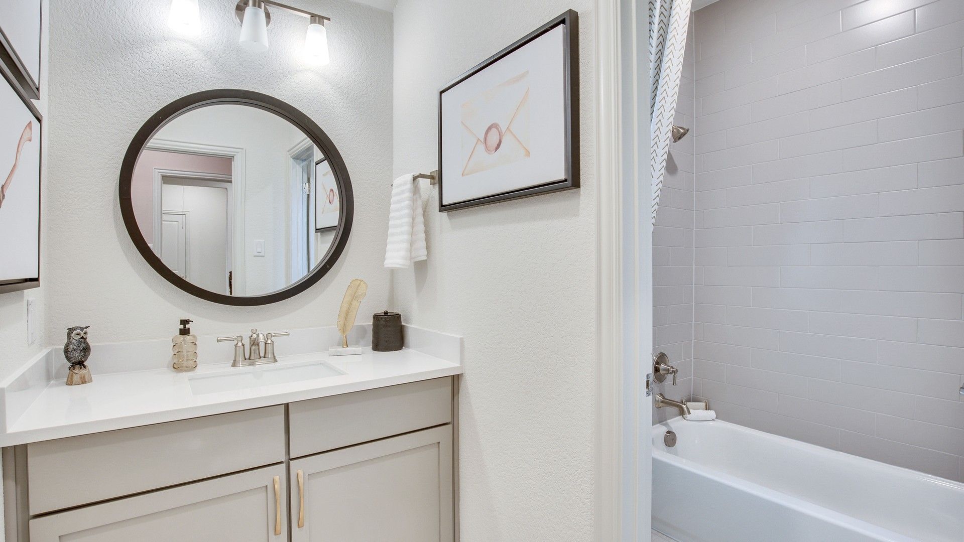 Elegant Opal Ranch bathroom with subway tile, round mirror, and sleek fixtures in a seamless design.