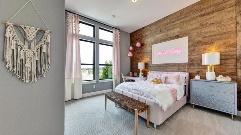 Elegant wood paneling and expansive windows enhance this Hawkes Landing bedroom's refined style.