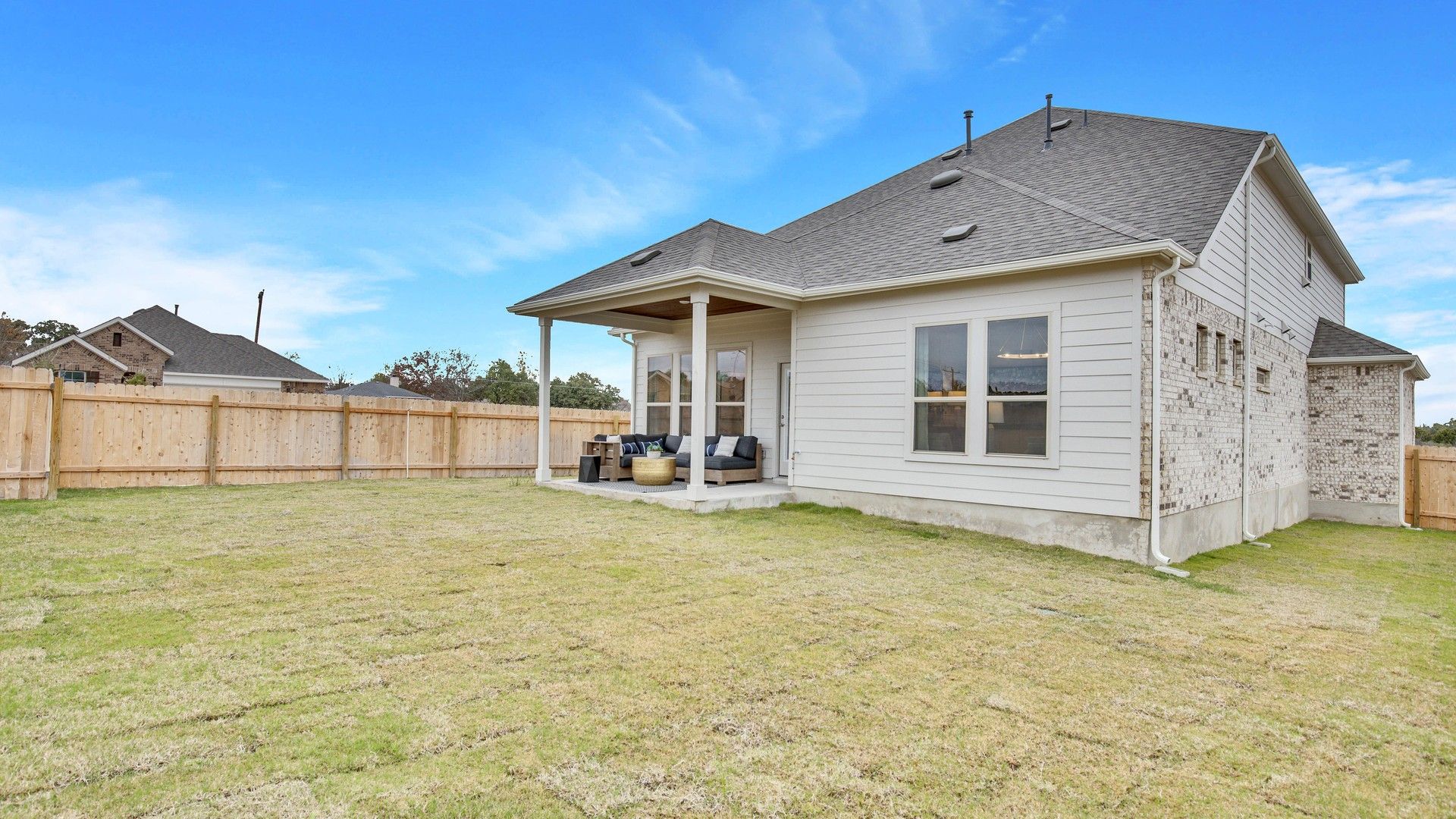 Elegant brick facade with covered patio creates a luxurious outdoor retreat in Opal Ranch.