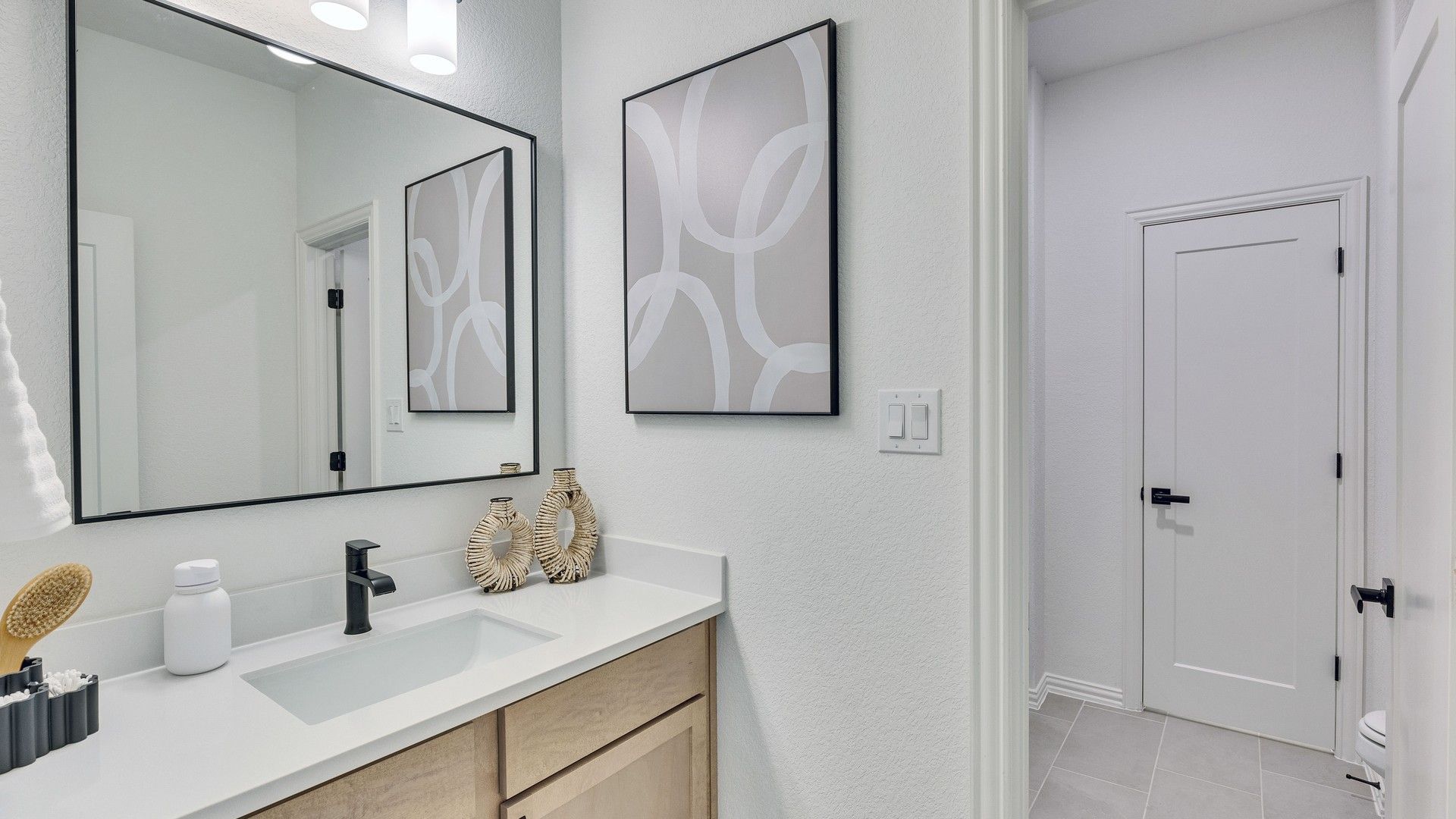 Sleek wood cabinetry and elegant contemporary fixtures enhance this Briarwood bathroom.
