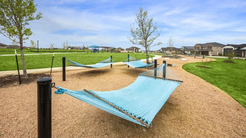 Embrace tranquility with elegant hammocks amidst lush greenery in Carillon community's upscale park.