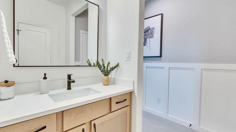Experience luxury with light wood vanity and sleek quartz countertop in Briarwood’s elegant homes.