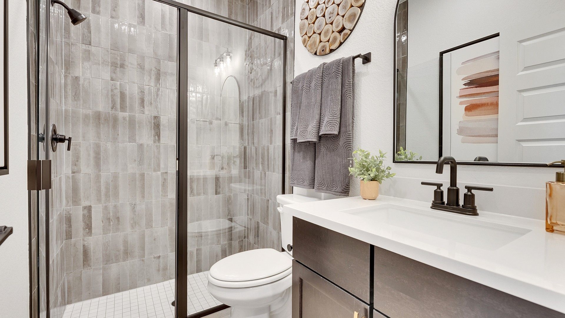 Sophisticated design with sleek glass shower and textured tiles in Spring Creek.
