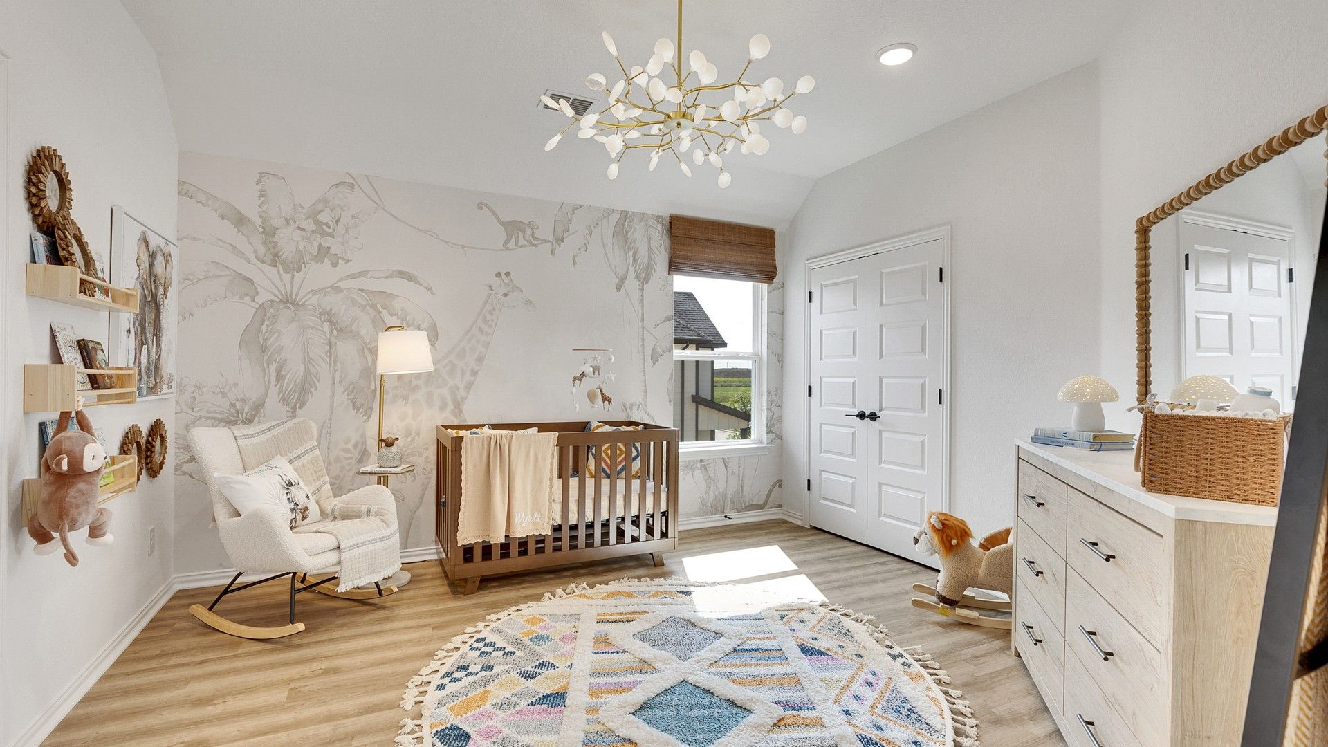 Luxurious nursery features a giraffe mural and modern chandelier, blending elegance with charm at Spring Creek.