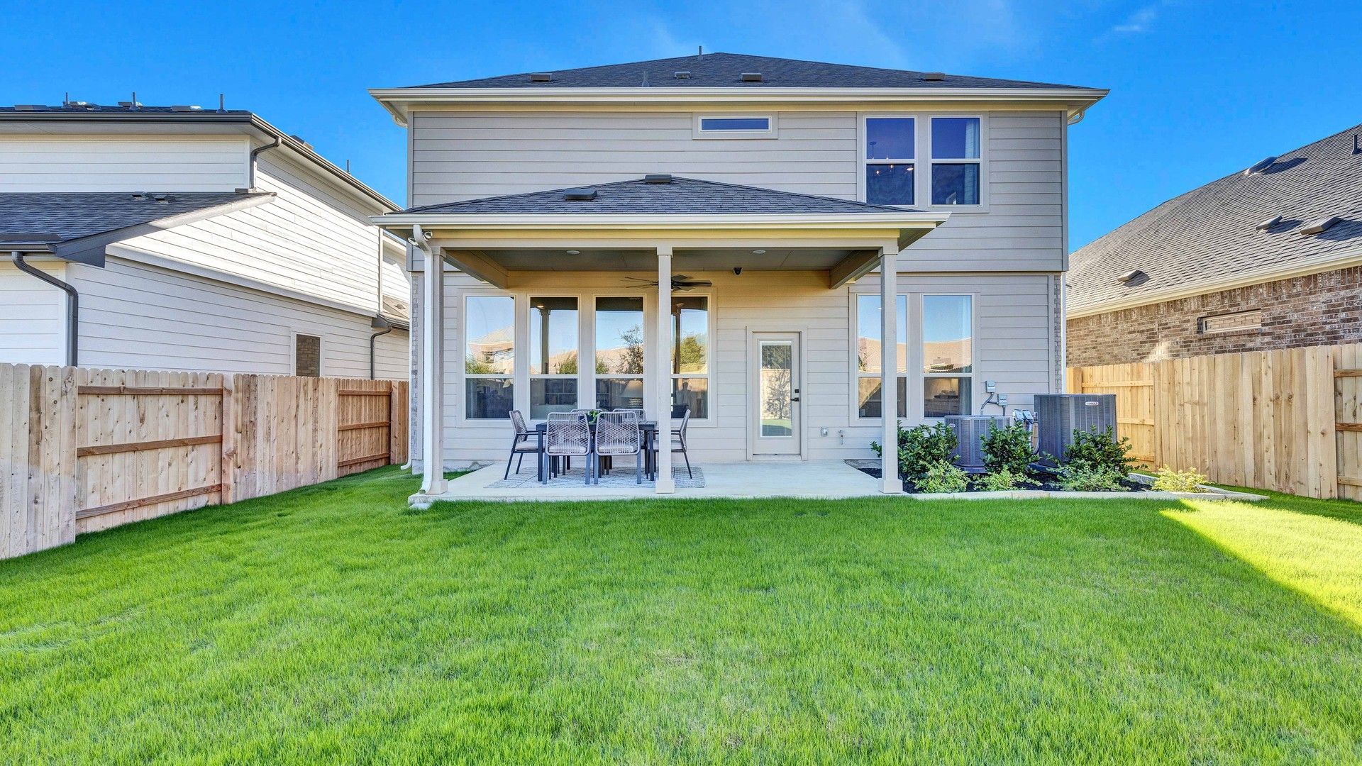 Elegant Briarwood home featuring a covered patio, pristine siding, and manicured lawn for luxurious outdoor living.