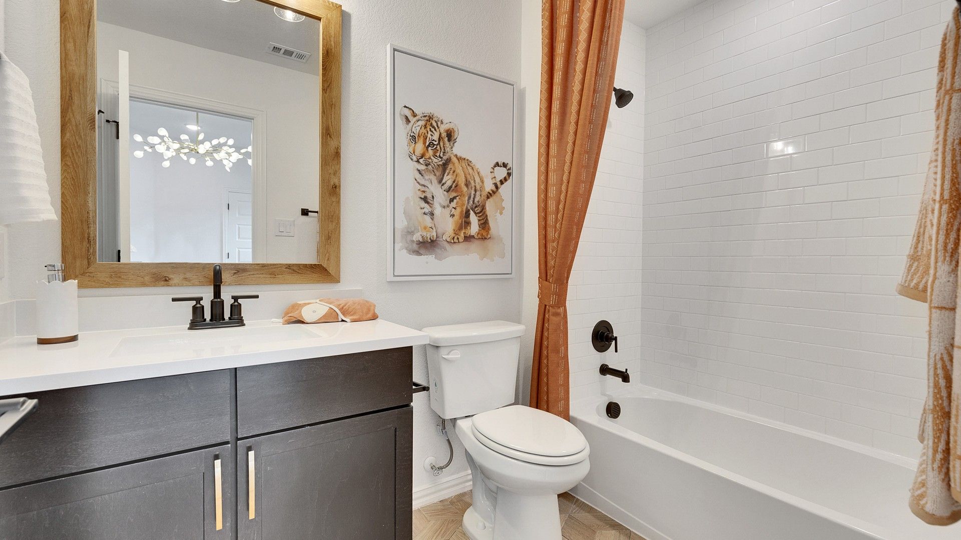 Luxurious bath featuring a chic dark vanity and warm wood accents in Spring Creek.