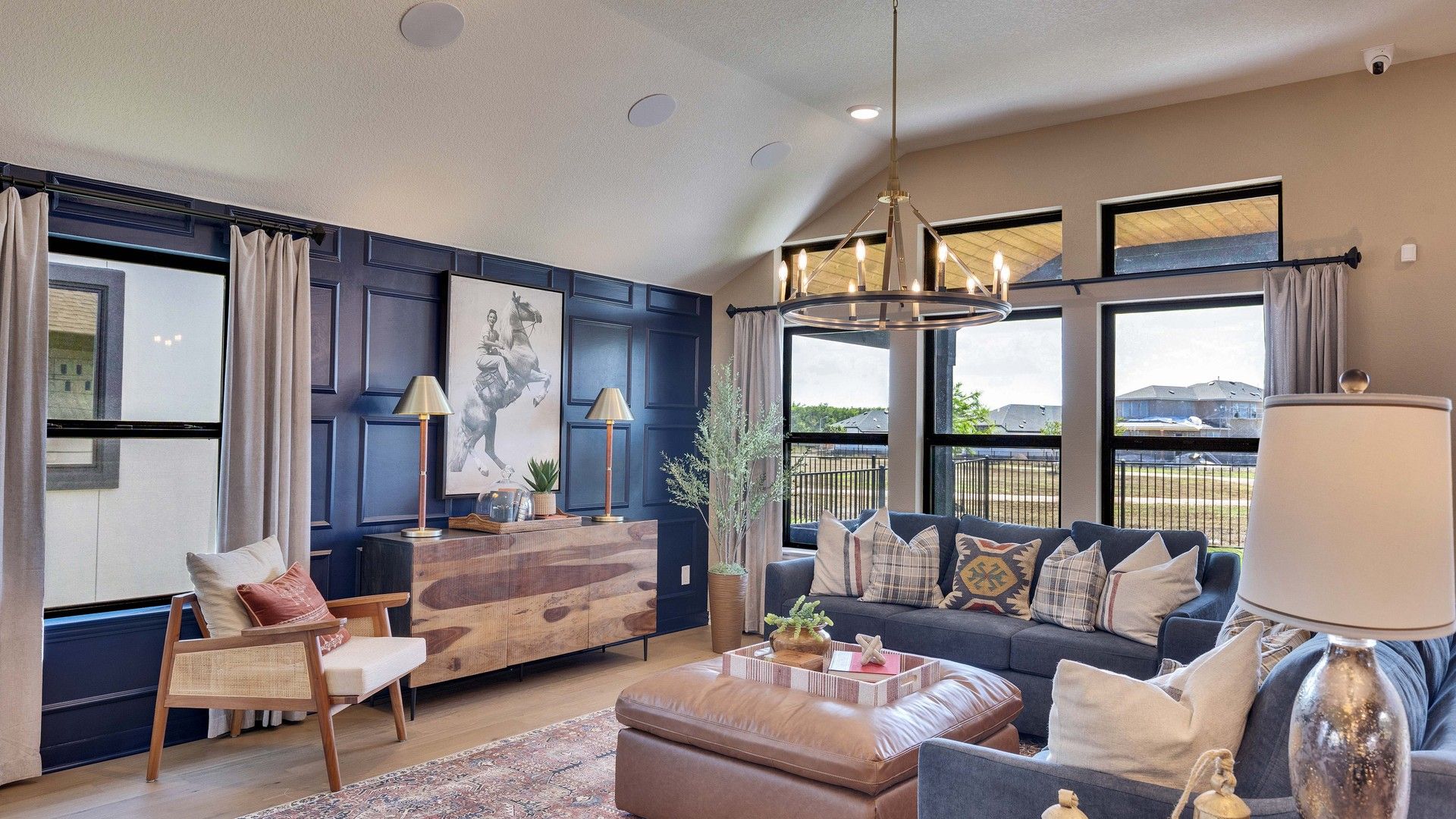 Revel in the opulence of a navy paneled accent wall, rich textures, and expansive windows in Lakeside Meadows.