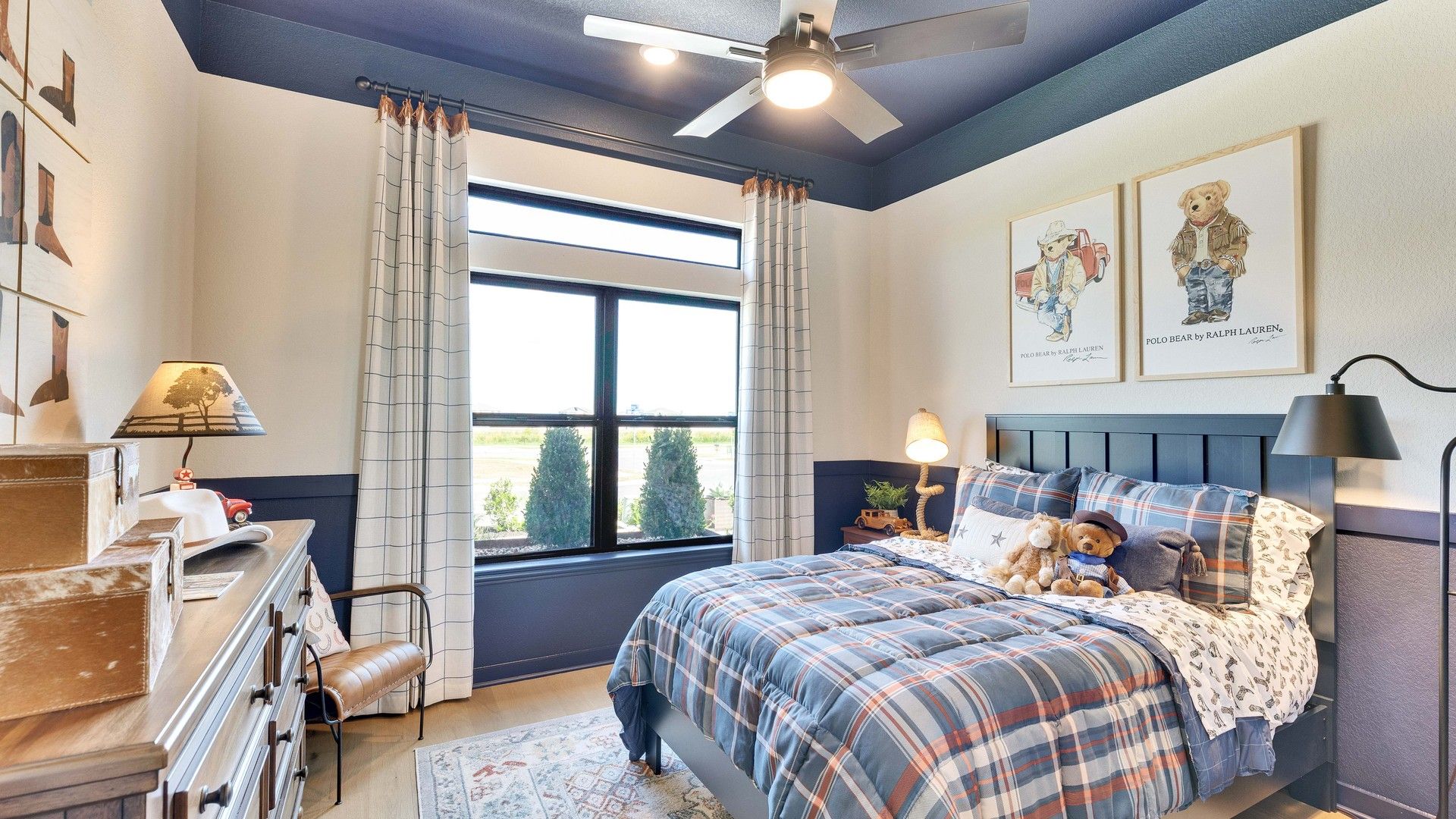 Features plaid bedding, cozy lighting, and expansive windows in Lakeside Meadows' refined dwelling.
