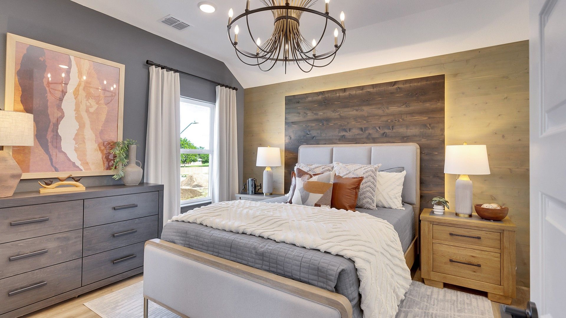 Exquisite wood accent wall and chandelier enhance this sophisticated Spring Creek bedroom.