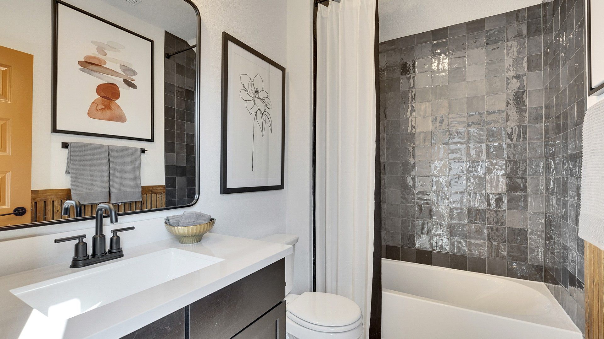 Elegant dark tile complements minimalist fixtures in Spring Creek's upscale bathroom.