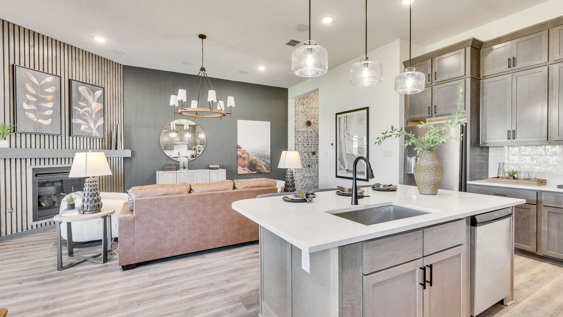 Experience elegance in Briarwood with a modern chandelier, sleek fireplace, and a sophisticated island kitchen.