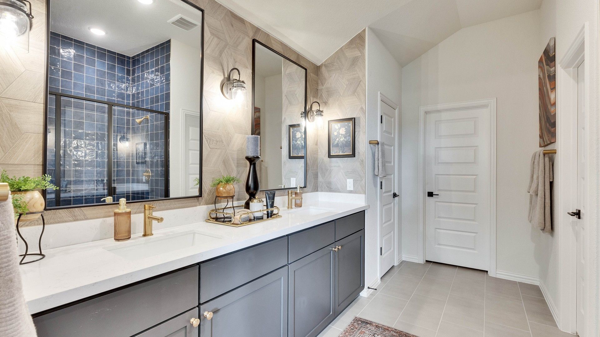 Sophisticated dual vanity with elegant gold fixtures, navy tiled shower, geometric walls in Lakeside Meadows.