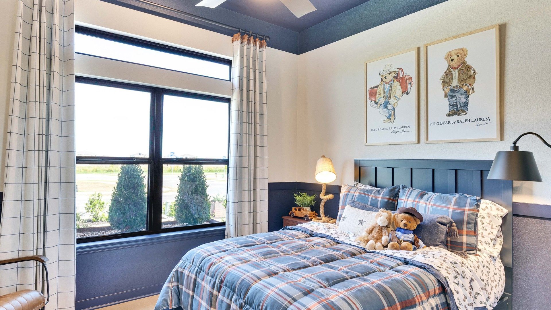 Elegant plaid bedding complements large windows and stylish art in this Preserve at Lakeside Meadows bedroom.