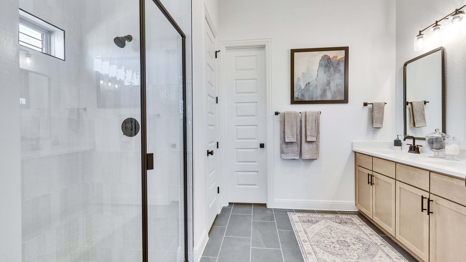 Luxurious Briarwood bathroom featuring a glass-enclosed shower and sophisticated black fixtures.