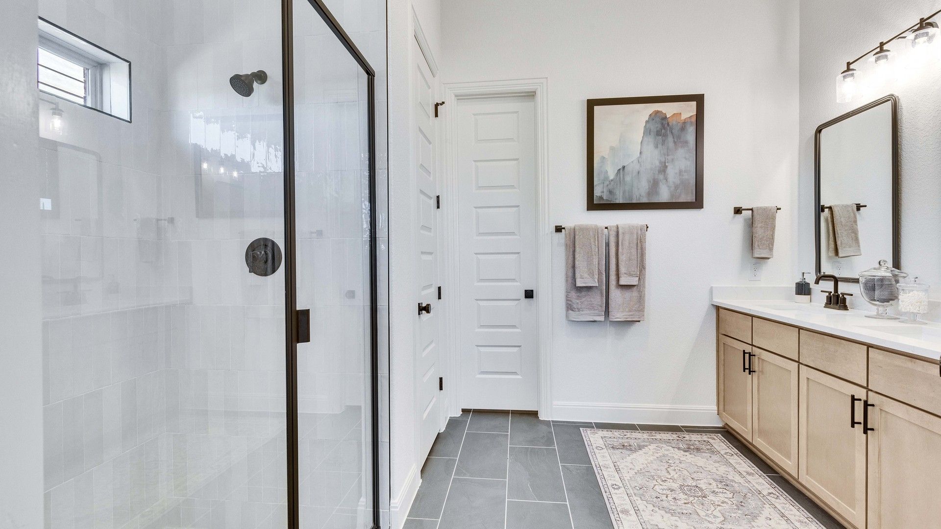 Luxurious Briarwood bathroom featuring a glass-enclosed shower and sophisticated black fixtures.