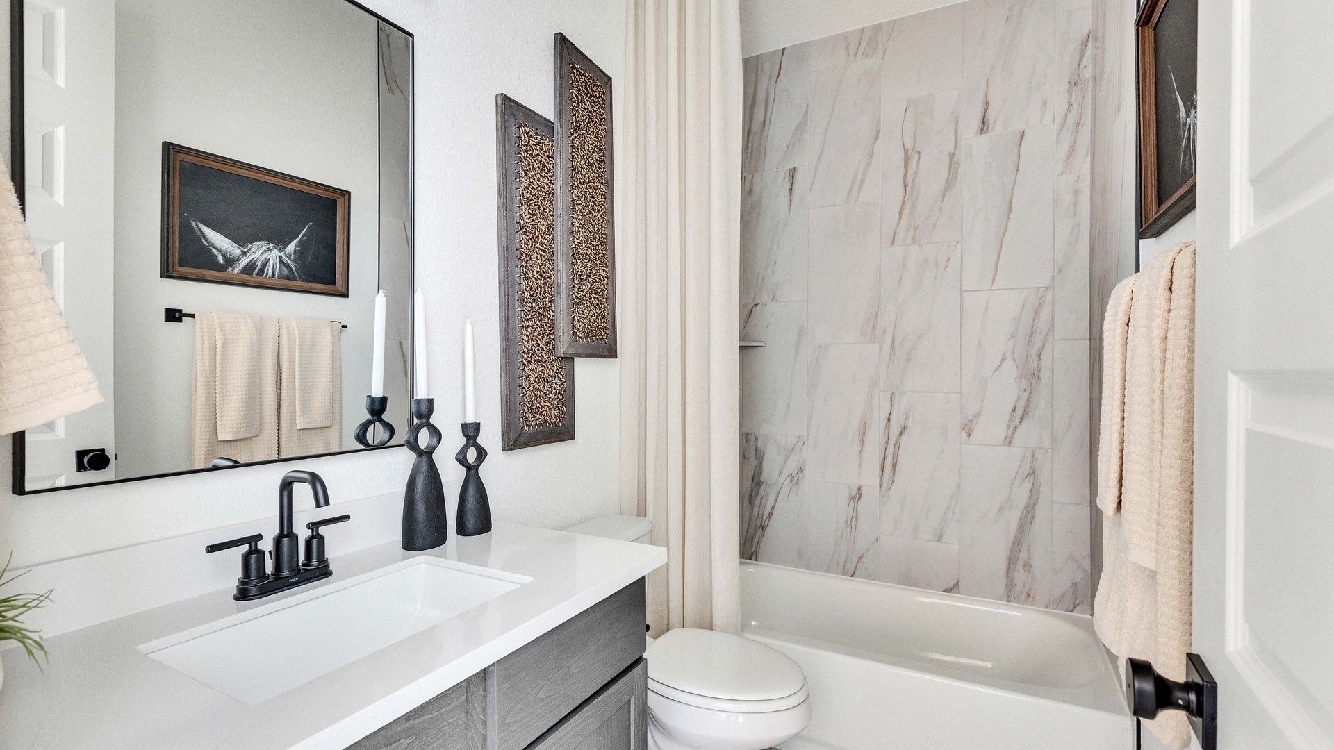 Indulge in opulence with marble tile walls and sleek fixtures in Briarwood, showcasing modern elegance.