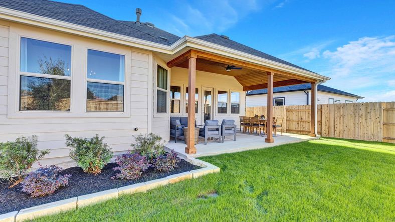 Revel in Briarwood's luxury with a chic covered patio, wooden pillars, and a beautifully manicured lawn.