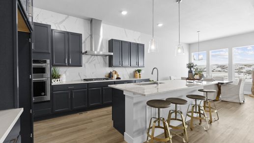 Sophisticated Montaine kitchen showcases marble surfaces, bespoke cabinetry, and expansive views through grand windows.