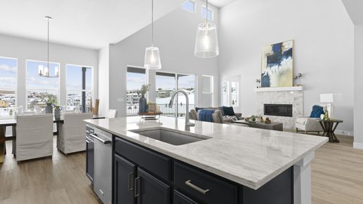 This Montaine home's kitchen boasts elegant marble counters and expansive windows, complemented by chic pendant lighting.