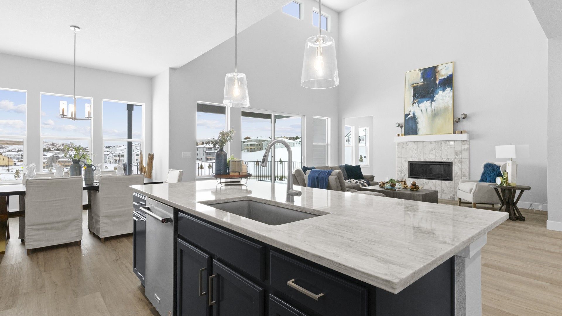 This Montaine home's kitchen boasts elegant marble counters and expansive windows, complemented by chic pendant lighting.