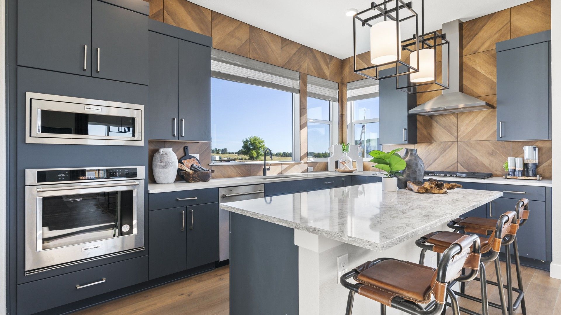 Experience elegance in Dillon Pointe's kitchen with marble counters, chic navy cabinets, and panoramic views.