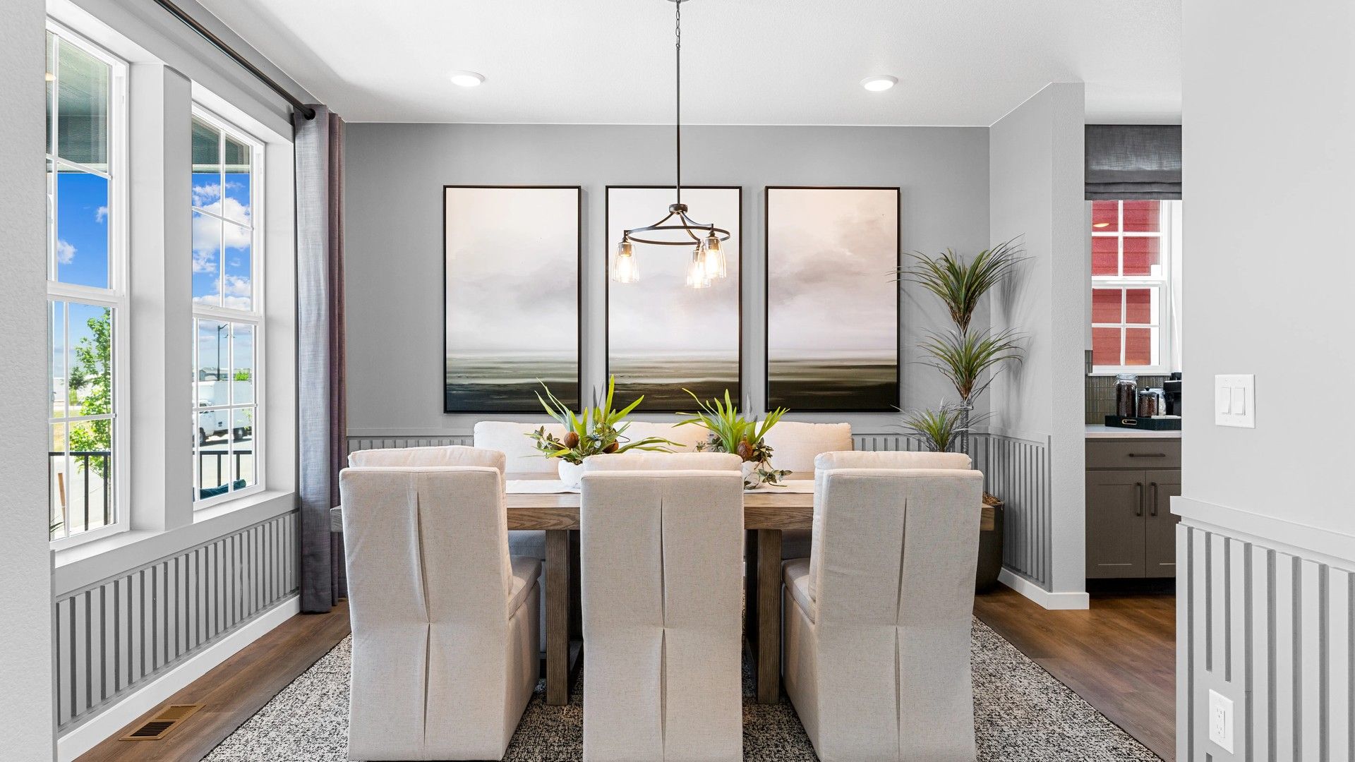 Luxurious Timnath Lakes dining features plush beige seating, modern lighting, art pieces, and expansive window views.