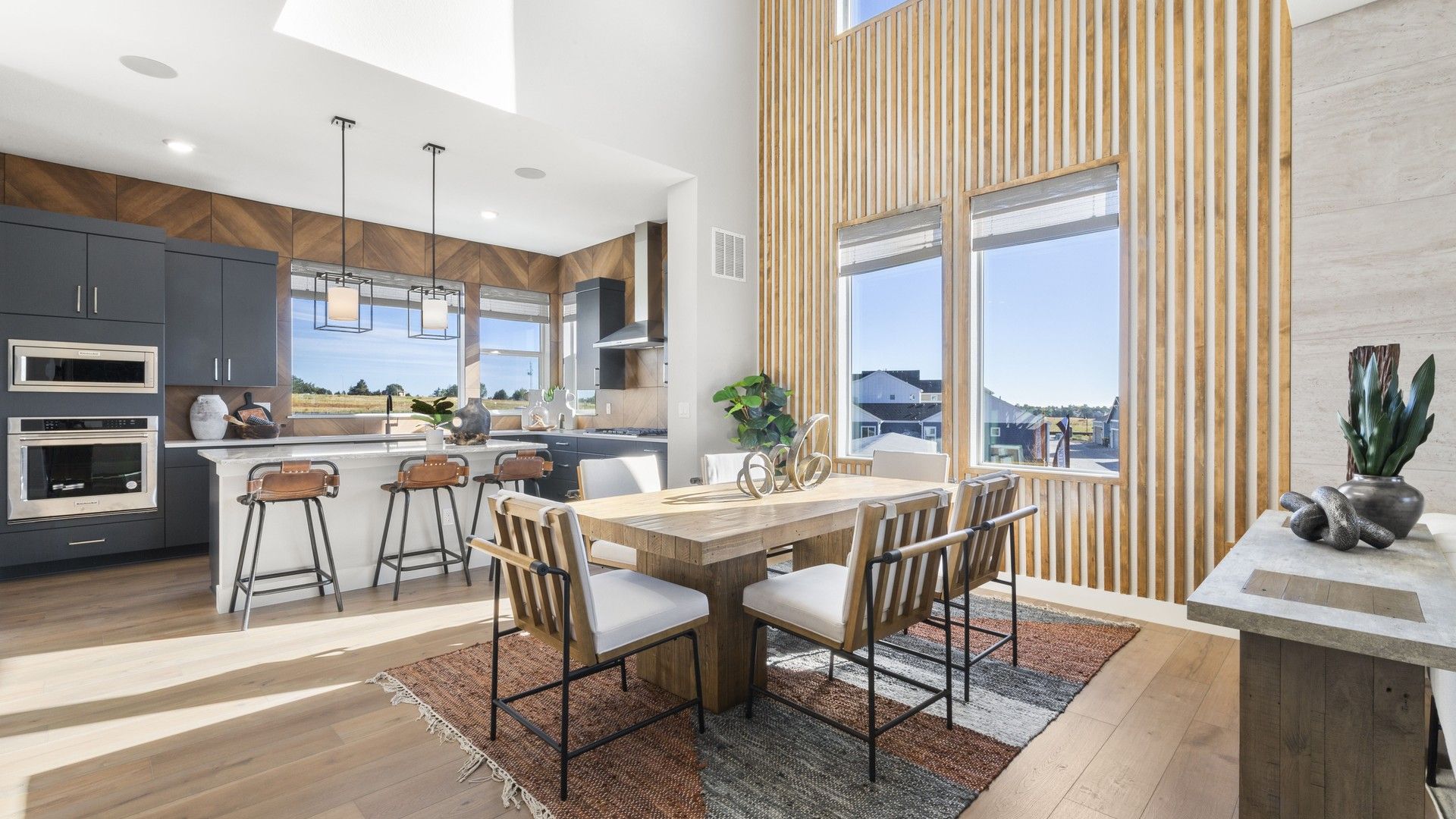 Elegant Dillon Pointe kitchen boasts vertical wood paneling and striking high ceilings.