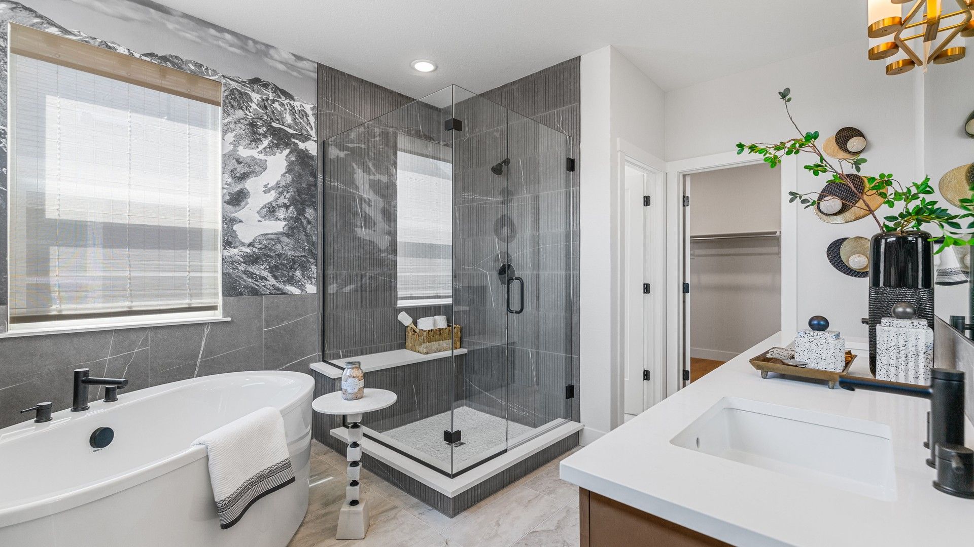 Experience refined elegance with a freestanding tub and an artistic mountain mural in Dillon Pointe's exclusive bath.